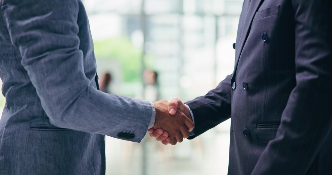 Due Uomini d'Affari si Stringono la Mano e Discutono in un Ufficio Moderno