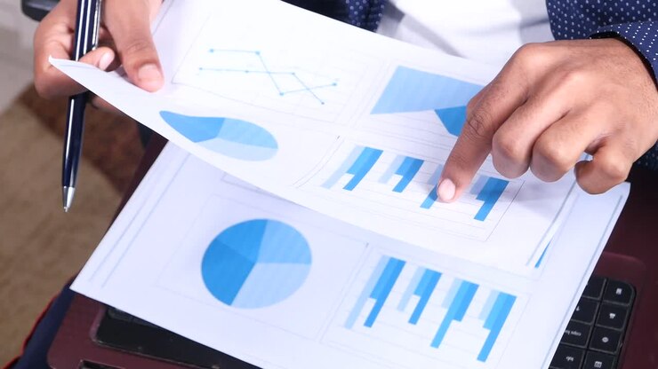 Person reviewing business documents with graphs and charts