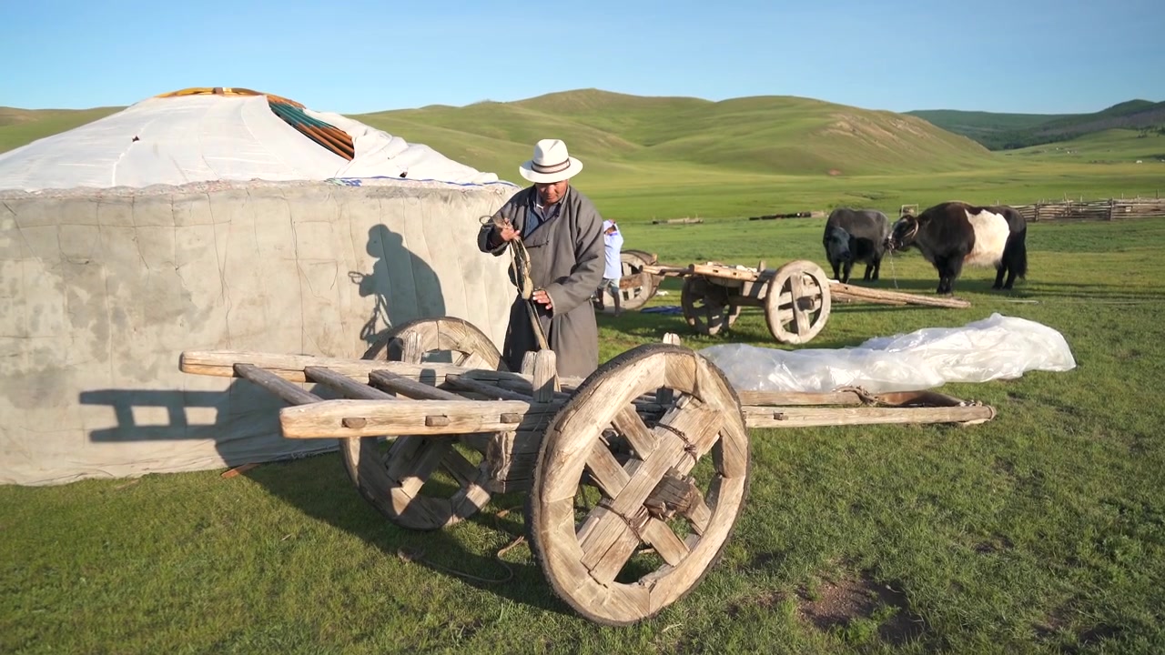 Uomo mongolo che prepara un carro di legno tradizionale fuori da una yurta
