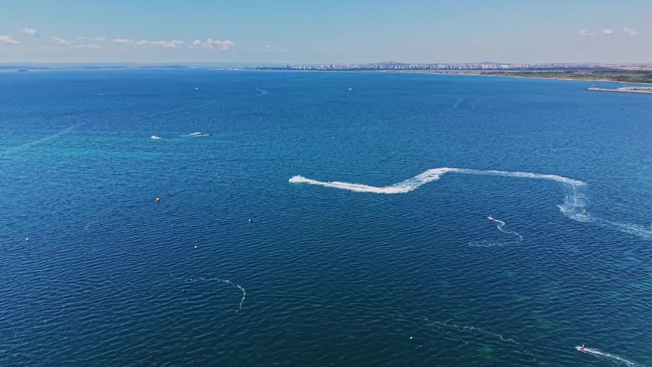 Vista di un ampio mare blu con barche in movimento in una giornata limpida e soleggiata