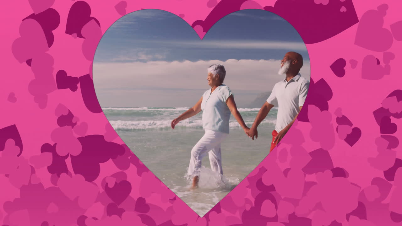 Holding hands, elderly couple walking on beach with heart shapes around them