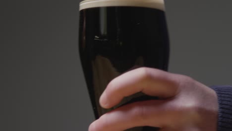 close up of two pint of irish stout in glass making a toast to celebrate st patricks day