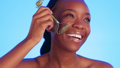 facial, jade roller and black woman in studio