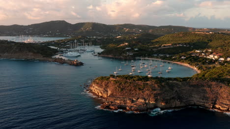 aerial shot of sunset in english harbor in antigua, caribbean with views of yachts, sailboats, marina, bay and cliffs