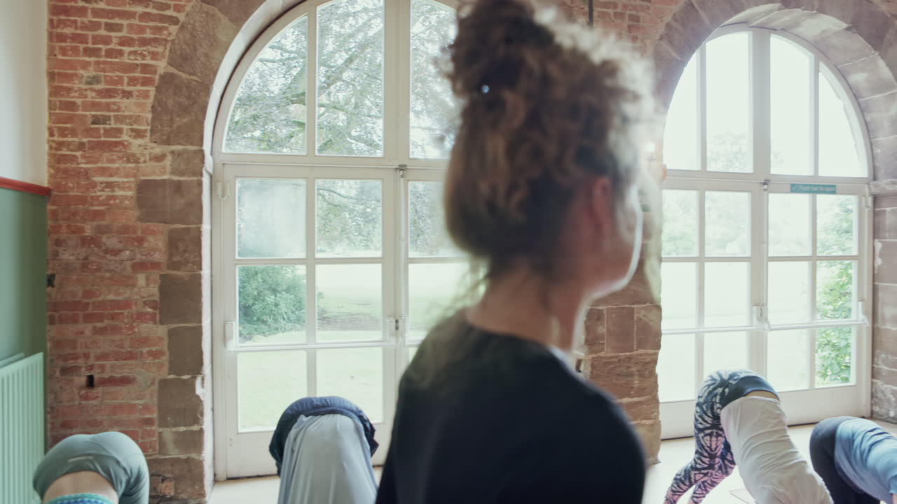 Yoga class practicing downward dog pose