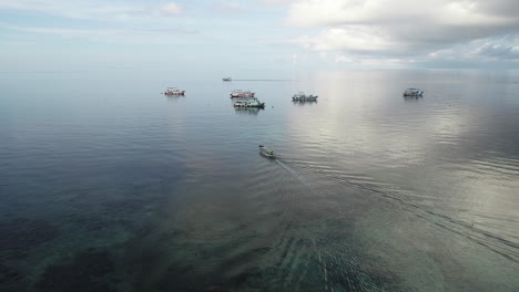 barco deslizándose hacia barcos anclados en la isla de tao