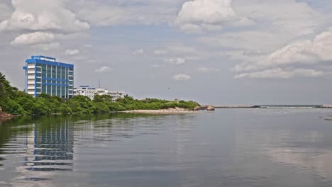 cooum river with indian coast guard regional headquarters and clouds near marina beach, triplicane, chennai, tamil nadu, india. day time, stable shot, 4k.