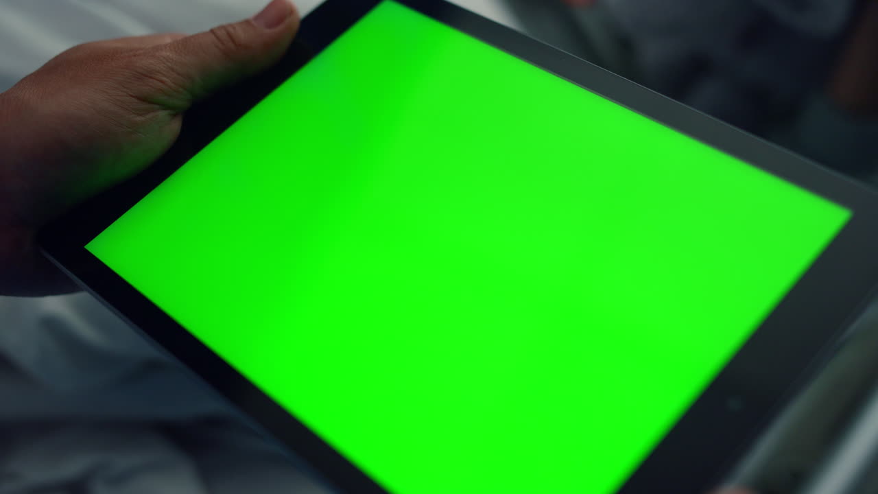 Man hands using tablet computer in clinic room closeup. Chroma key device screen