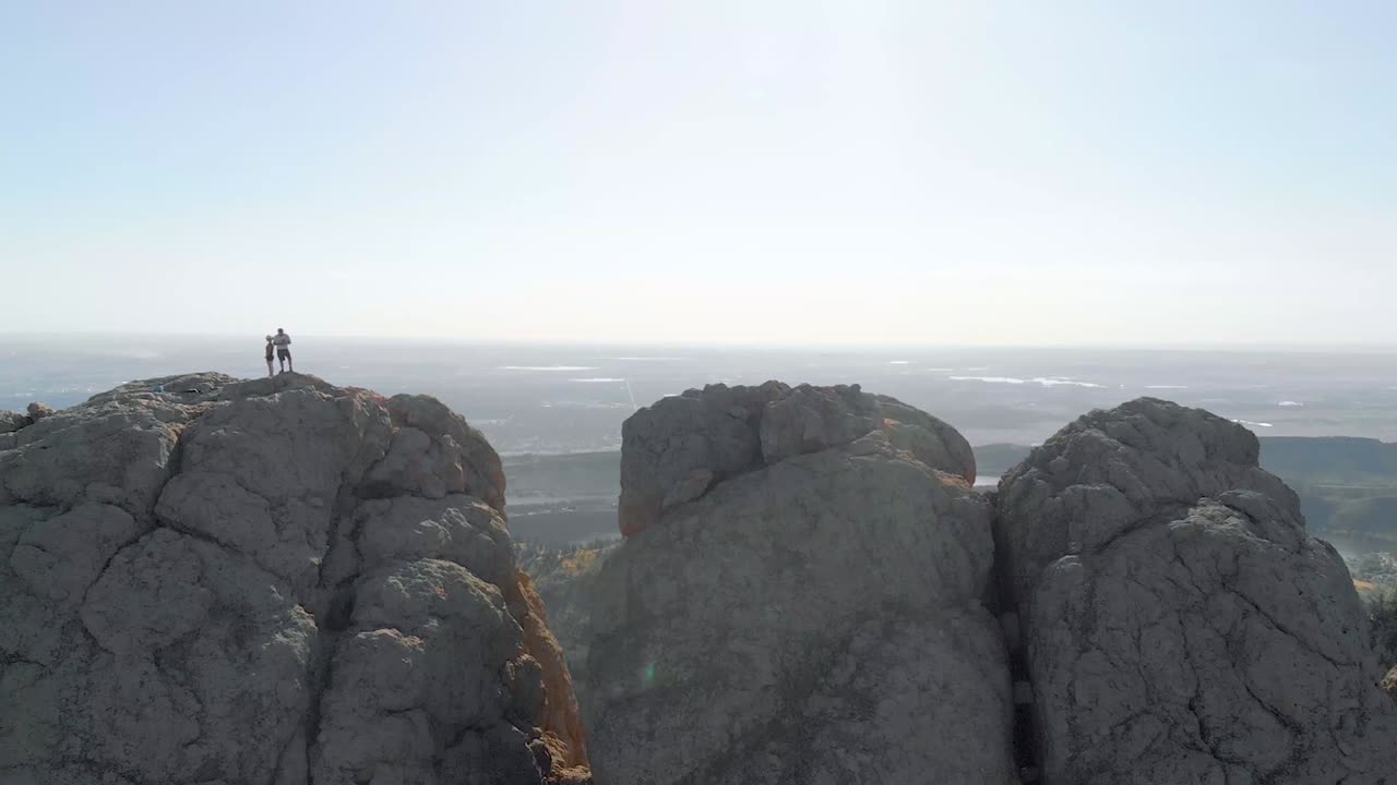 멀리 있는 산악 지형, 등산객 및 도시 풍경의 드론 샷