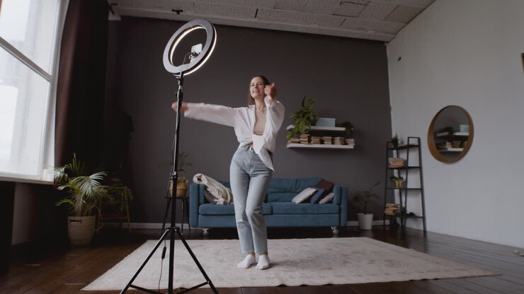Vidvinkelbillede af en influencer-kvinde, der filmer sine dansetrin for at uploade dem til TikTok.