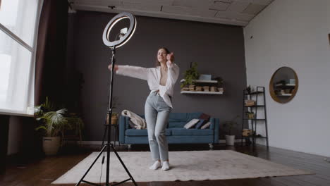 wide shot of a influencer woman shooting her dance steps to upload it to tiktok