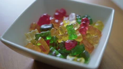 close up pan right of a bowl of gummy bears