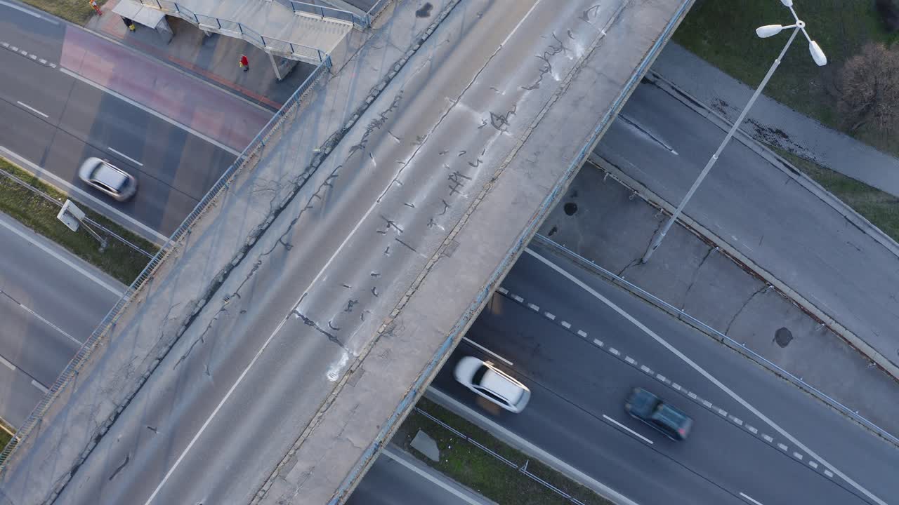 다리에 아스팔트가 파괴되고 버스 정류장에 빨간 버스가 있는 다층 도시 고속도로의 아침 가운 교통