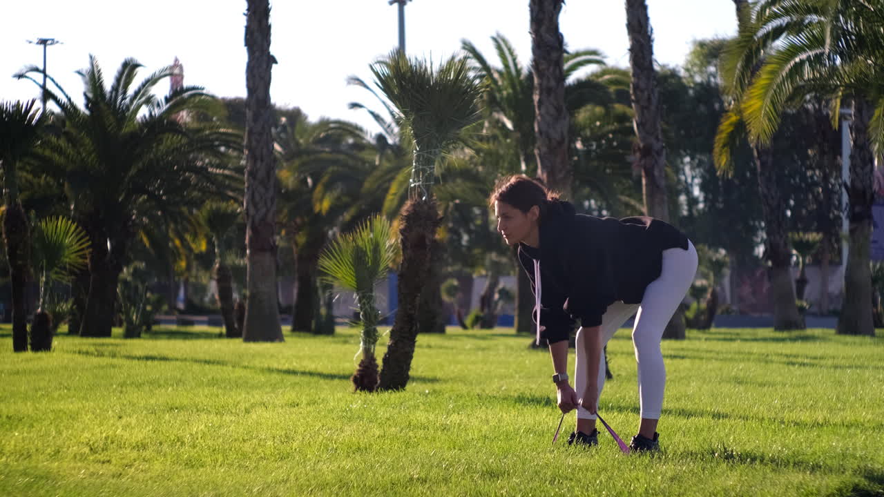mujer haciendo ejercicio al aire libre con banda de resistencia