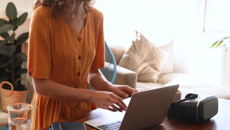 mujer caucásica usando una computadora portátil en casa