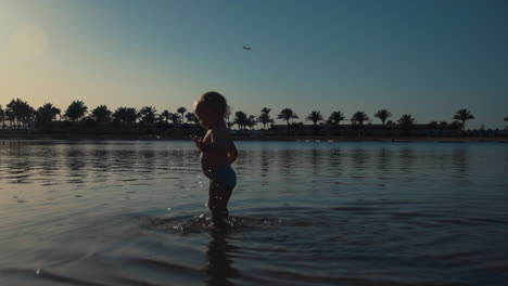 Süßer-Junge,-Der-Am-Meer-Im-Meerwasser-Spaziert.-Glückliches-Kind,-Das-Den-Sommer-Am-Strand-Genießt.