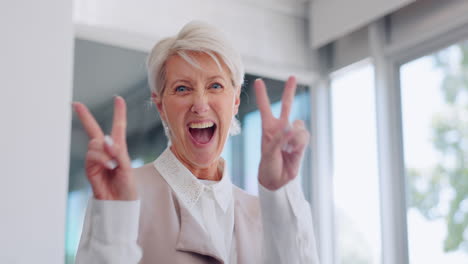 mujer de negocios sénior, signo de la mano de la paz con la cara
