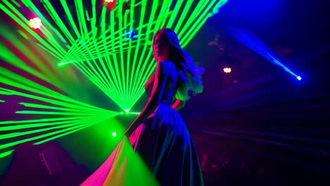 woman dancing amidst vibrant laser lights in a nightclub setting