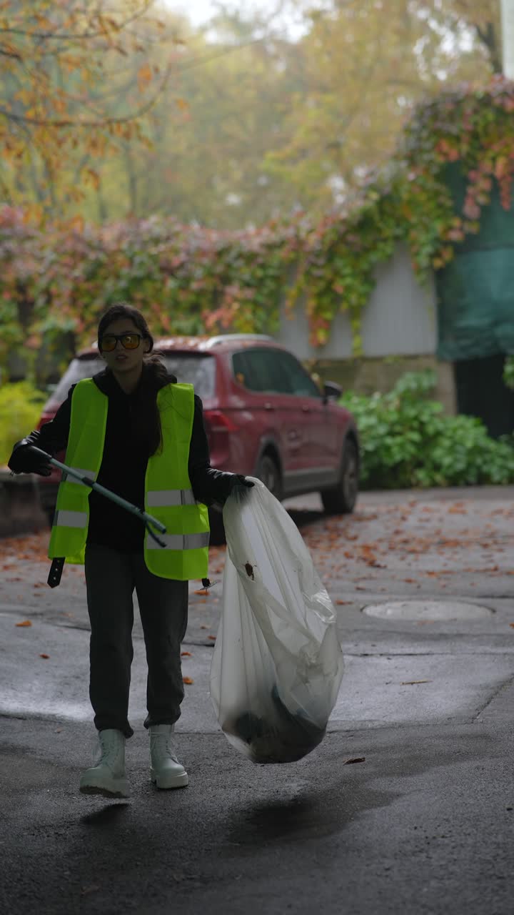 mujer limpiando la basura en un parque de la ciudad