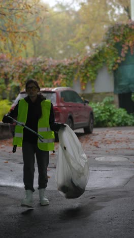 woman cleaning up trash in a city park