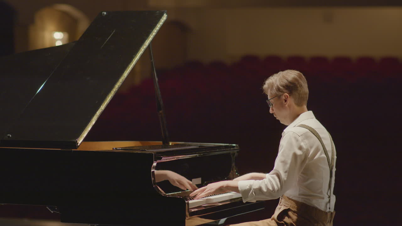 Pianist Practicing Piano on Stage in Concert Hall
