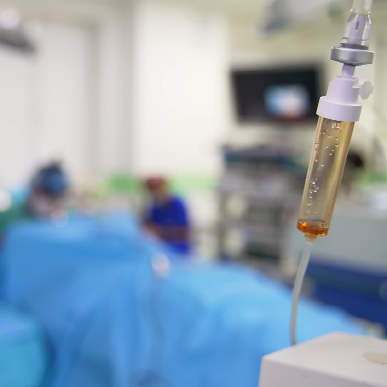 Attrezzatura in una sala operatoria moderna. Contagocce con farmaci che gocciolano. Intervento chirurgico sullo sfondo sfocato