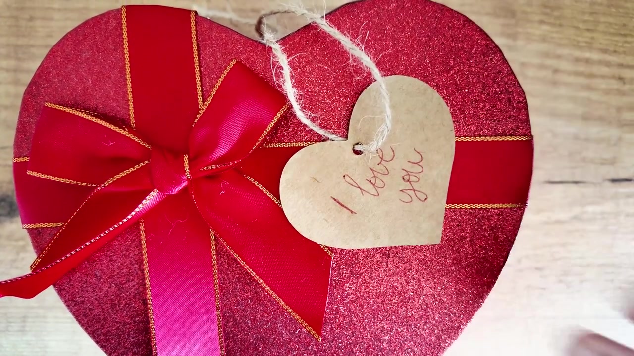 Escribiendo “Te amo” en una etiqueta de regalo. Mensaje romántico hecho a mano