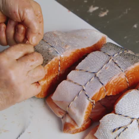 a worker slices pieces of salmon in a canned food factory 2