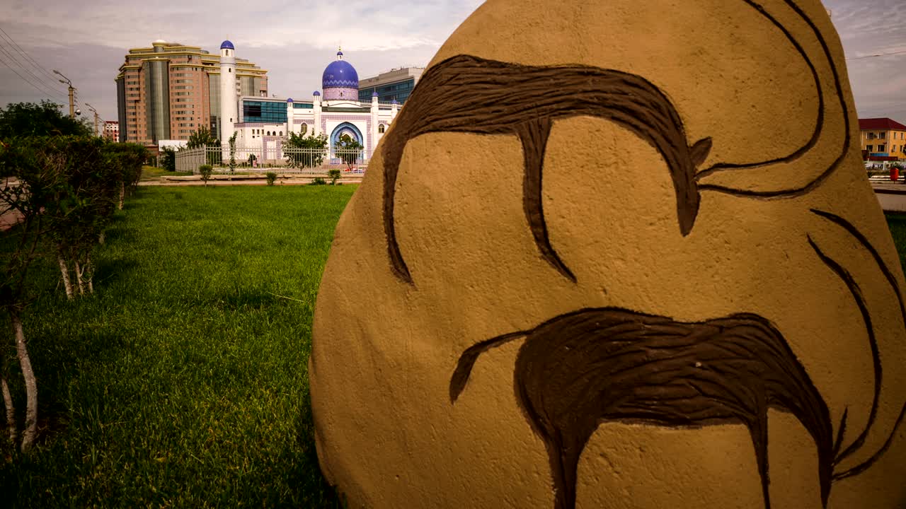 카자흐스탄, 아티라우, 타임스, 고대 그림이 그려진 돌, 배경에 모스크, 현대 도시