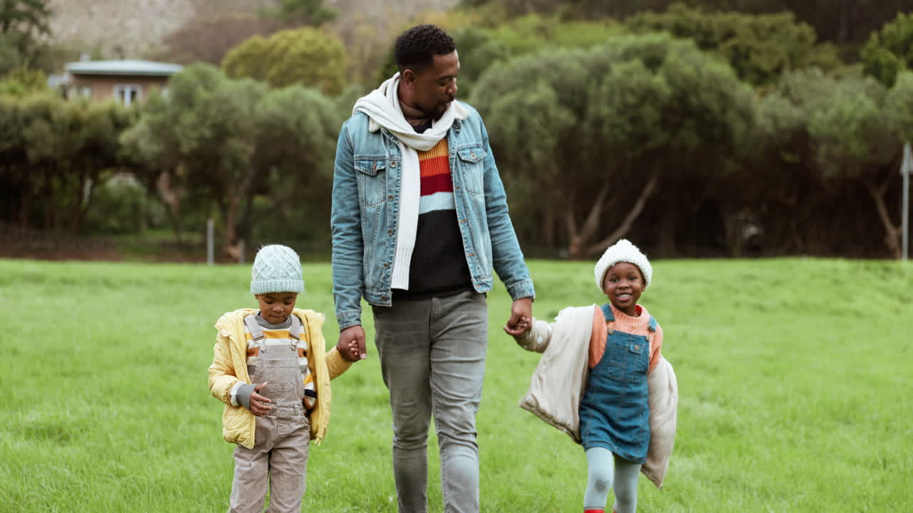Padre, amore e bambini che si tengono per mano al parco
