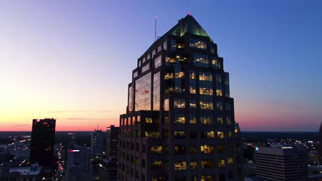 stunning twilight view: a captivating perspective of a majestic skyscraper illuminated against a vibrant sunset sky