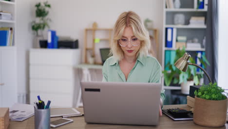 Woman-Focused-on-Work-on-Laptop-in-Office