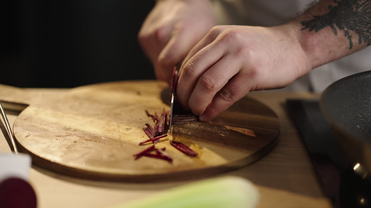 Chef cutting beetroot on a wooden board