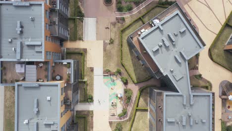 AERIAL:-Lines-of-Buildings-with-Futuristic-Looking-Playgrounds