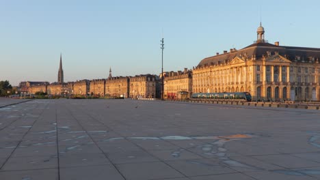 sunrise at the water mirror in bordeaux with nobody in sight and tramway in the background, slow wide pan