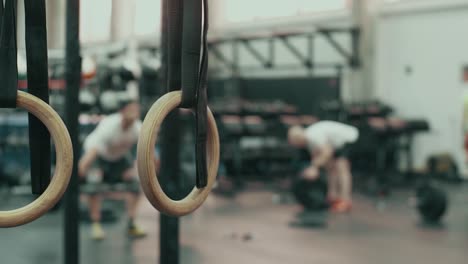 people exercising with rings in a gym