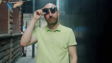 man in a green polo shirt in an urban alley