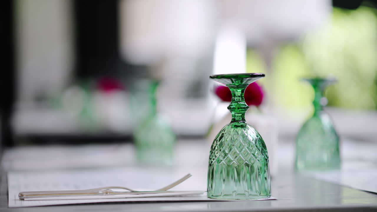 Close up of a green glass, placed upside down on a table at a restaurant