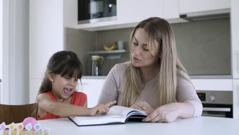 mom teaching little daughter to read