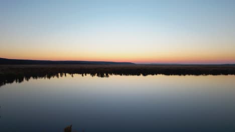 Cámara-Moviéndose-Lentamente-Sobre-La-Superficie-Del-Agua-De-Un-Delta-Natural-Al-Atardecer,-Parque-Natural-De-Comana,-Rumania