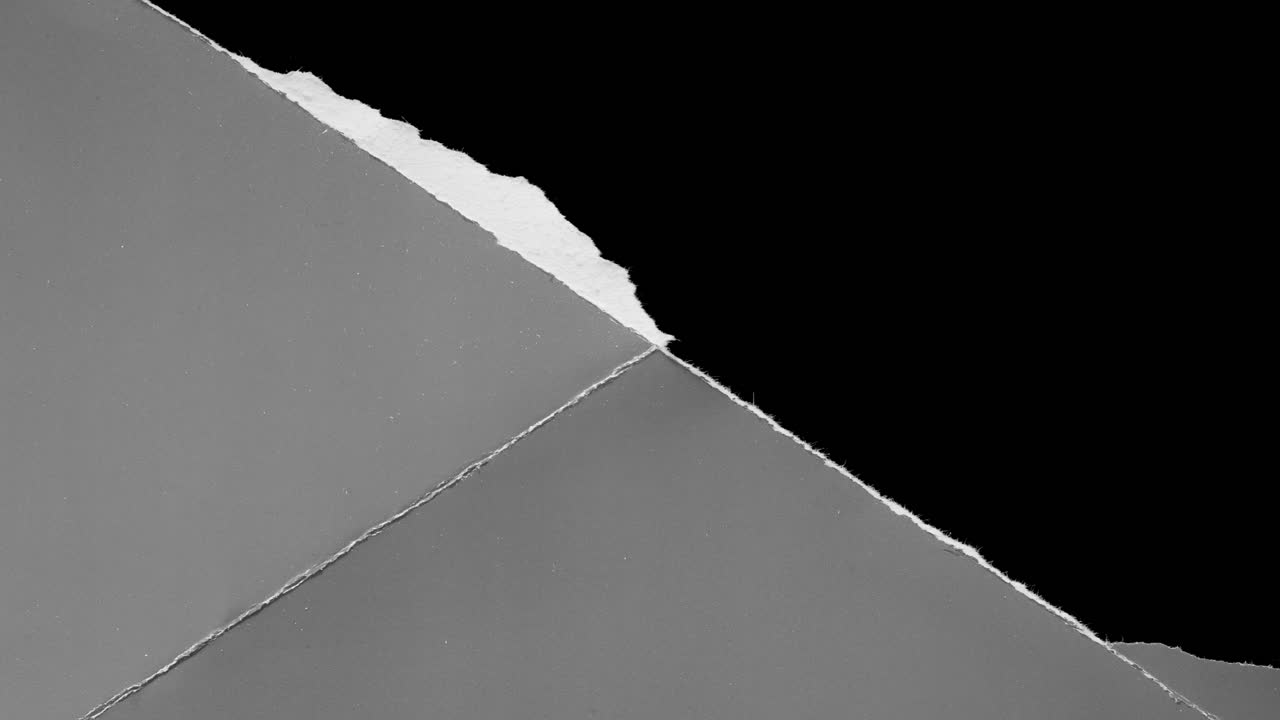 Abstraktes Reißen von grauem Papier auf schwarzem Hintergrund