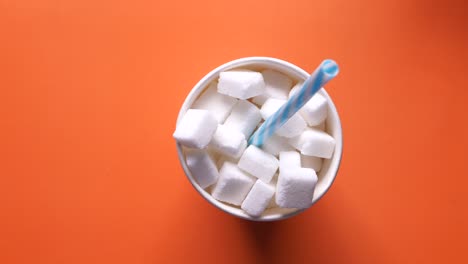 sugar cubes in a paper cup with a straw