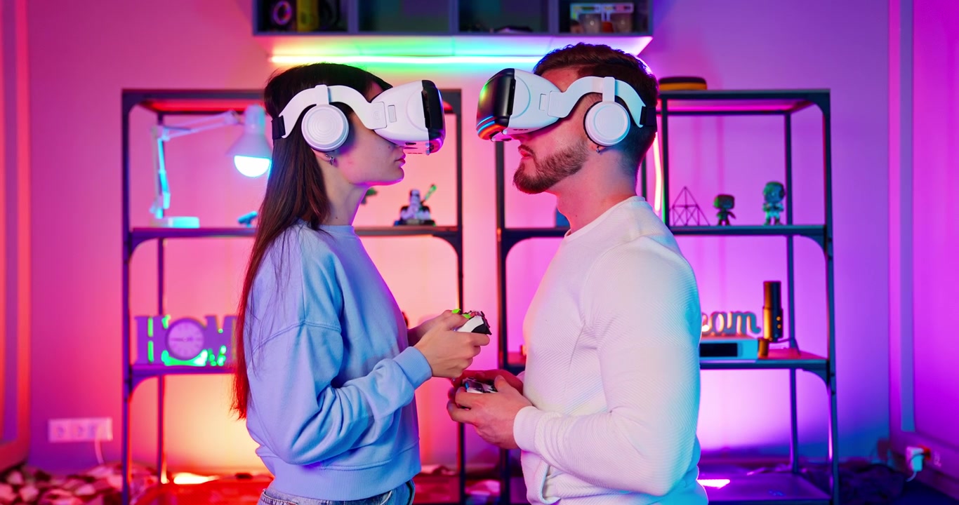 Giovane coppia che gioca a un gioco di realtà virtuale con illuminazione al neon