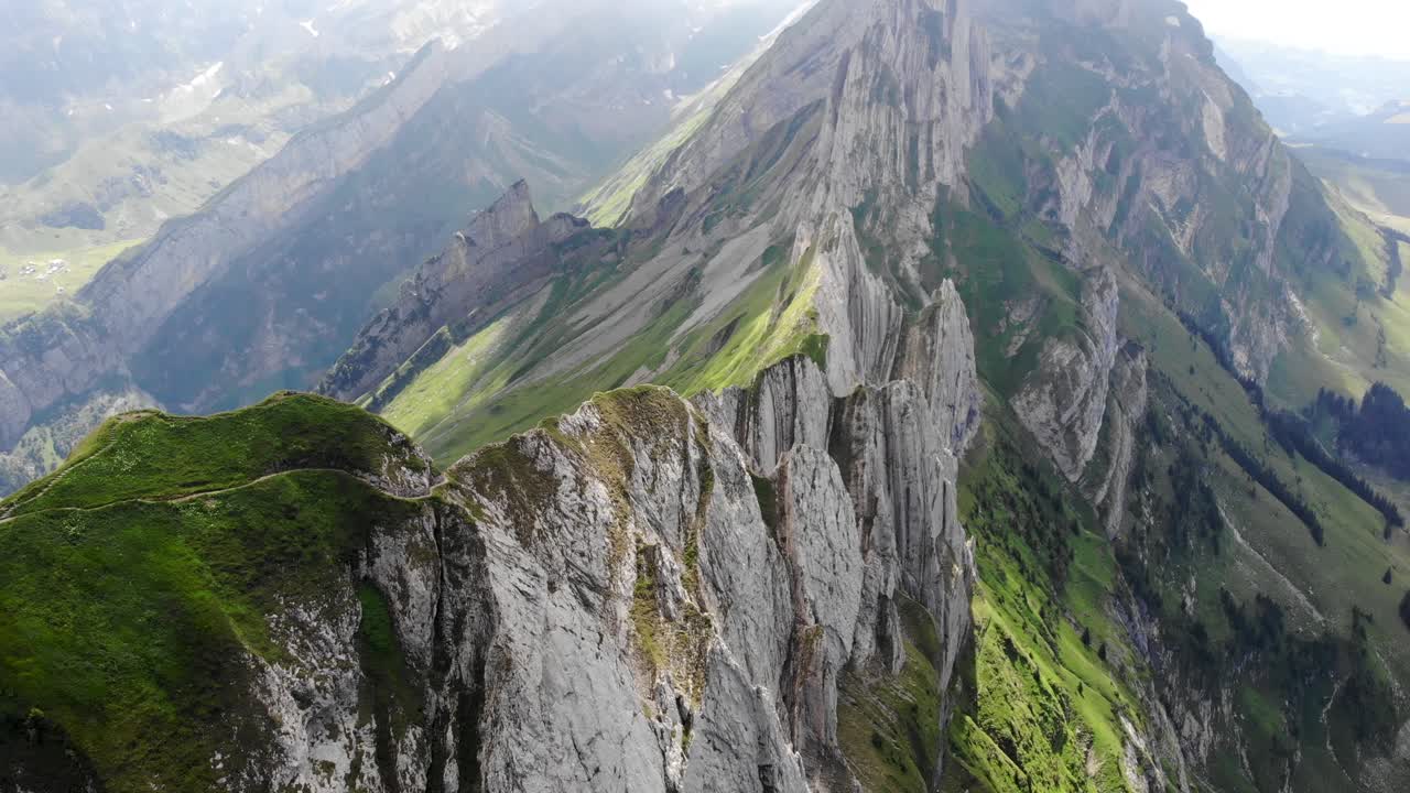 sobrevuelo aéreo sobre los acantilados de schafler ridge en appenzell, suiza con pan hacia las montañas incluyendo altenalpturm