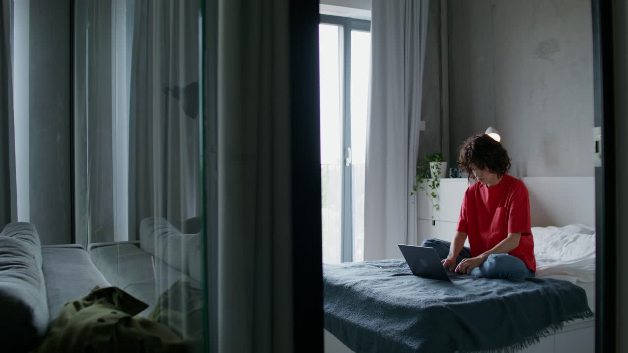 편안한 침실에서 노트북에서 일하는 여자