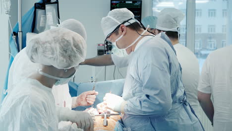 scrub nurse gives tools to surgeon. experienced surgical team performs surgery on patient heart treating coronary artery disease in operating room