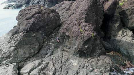 Male-Hiker-Trekking-On-Massive-Rock-Formation-By-The-Sea-In-Catanduanes,-Philippines