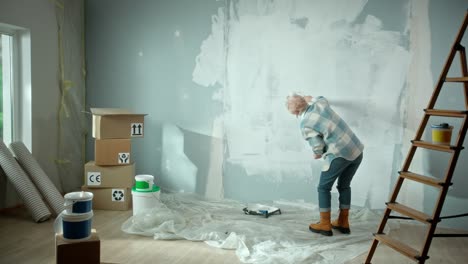 elderly woman painting wall with white paint using.mov | apron, art, brush, bucket