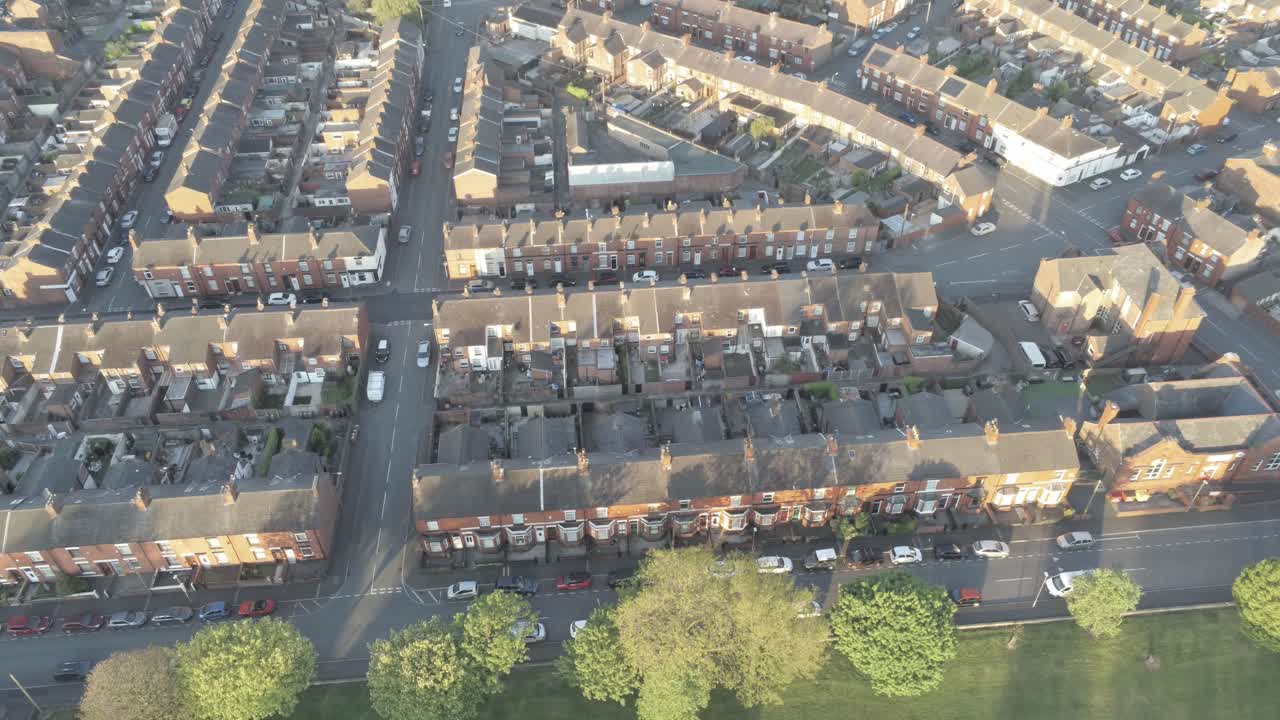 Veduta aerea sopra un tipico quartiere residenziale britannico all'alba, ripresa a volo d'uccello in discesa