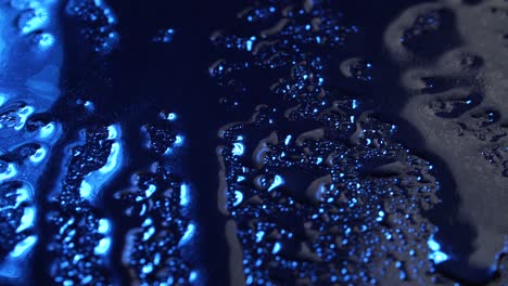 imágenes de gotas de lluvia sobre un fondo de vidrio azul